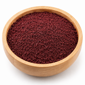 Ground burgundy sumac in a wooden bowl